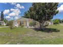 Inviting single-story home featuring a well-maintained lawn, mature tree, and a welcoming front porch at 3707 Cambridge St, New Port Richey, FL 34652