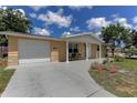 Inviting single-story home with attached garage, front lawn, and charming covered entryway at 3707 Cambridge St, New Port Richey, FL 34652