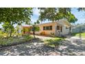 Side view of the house with lovely landscaping, a small yard, and mature trees providing shade at 4720 Coronado S Way, Gulfport, FL 33711
