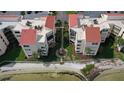 Aerial shot of condo buildings with red tile roofs, landscaping, and water views at 5633 Puerta Del Sol S Blvd # 310, St Petersburg, FL 33715