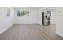 Bright living room with gray floors, white walls, and stainless steel refrigerator at 7516 S Obrien St, Tampa, FL 33616