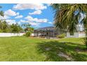 Large, fully fenced backyard featuring a screened lanai with an inground pool on an expansive green lawn at 10811 Providence Oaks Dr, Riverview, FL 33578