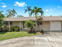 Inviting single-story home with manicured lawn, mature trees, and a paved driveway at 11460 Park Blvd, Seminole, FL 33772