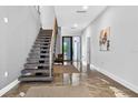 Contemporary entryway with floating stairs, high ceilings, and polished floors leading to a bright living space at 131 Forest Hills Dr, Redington Shores, FL 33708