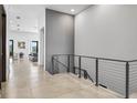 Upstairs hallway view showcasing modern railing, access to the living room, and ample natural light at 131 Forest Hills Dr, Redington Shores, FL 33708