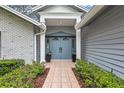 Inviting entryway with a double door, white trim, and tiled walkway surrounded by fresh landscaping at 134 Barrington Dr, Brandon, FL 33511
