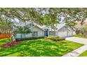 Charming single-story home featuring a three car garage, landscaped yard and large shade tree at 134 Barrington Dr, Brandon, FL 33511