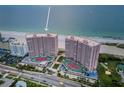 Aerial view of pink high-rise condominiums featuring red tennis courts and beautiful beach at 1340 Gulf Blvd # 8C, Clearwater Beach, FL 33767