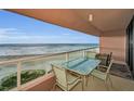 Balcony with a table and chairs overlooking a sandy beach with ocean views at 1340 Gulf Blvd # 8C, Clearwater Beach, FL 33767