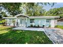 Inviting home with new walkway, green lawn and fresh landscaping with mature palms and plantings at 2121 Dodge St, Clearwater, FL 33760