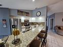 Open kitchen features granite countertops, stainless steel appliances, and breakfast bar seating at 2210 Bayou Dr, Holiday, FL 34691