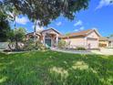 Beautiful single-story home with manicured lawn and mature trees at 22804 Willow Lakes Dr, Lutz, FL 33549