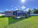 Backyard view of a screened-in private pool with lush landscaping at 22804 Willow Lakes Dr, Lutz, FL 33549