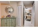 Hallway features decorative cabinet, mirror, and glimpse into the bathroom at 2333 Feather Sound Drive # A409, Clearwater, FL 33762