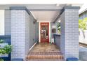 Inviting front porch showcasing brick columns, a red front door, and tile flooring, enhancing curb appeal at 304 21St N Ave, St Petersburg, FL 33704