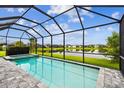 Screened-in pool and hot tub overlooking a serene lake and green backyard at 3326 Woodmont Dr, Parrish, FL 34219