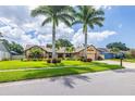 Inviting home exterior featuring lush landscaping, palm trees, and a well-maintained front yard at 3437 Aspen Trl, Clearwater, FL 33761