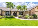 Charming home with beautiful landscaping, mature plants, and a well-manicured lawn at 3437 Aspen Trl, Clearwater, FL 33761