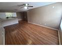 The living room is illuminated by ceiling fan lights and features wood floors, with an opening to the kitchen area at 36137 Lake Chase Blvd # 102, Zephyrhills, FL 33541
