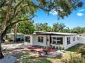 Inviting single-story home with black trim windows and a beautiful landscaped yard with stone and plants at 4112 W Lawn Ave, Tampa, FL 33611