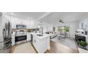 Modern kitchen with stainless steel appliances, white cabinetry, an island sink and an open floor plan at 4112 W Lawn Ave, Tampa, FL 33611