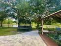 Enjoy the backyard's scenic lake views, a trampoline, and a cozy patio with a gazebo at 4522 Lisette Cir, Brooksville, FL 34604