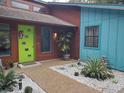 Stylish front entryway featuring a vibrant green door, modern landscaping, and a mix of textures at 5017 E 127Th Ave, Temple Terrace, FL 33617