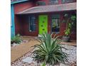 Inviting entrance with a bright green door, contemporary landscaping, and a well-maintained exterior at 5017 E 127Th Ave, Temple Terrace, FL 33617