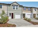 Townhome exterior featuring attached garages, brick driveway, and colorful siding details at 7683 Deer Valley Circle, Tampa, FL 33635