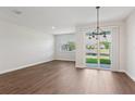 Open-concept room with wood-look tile flooring, a large window, and backyard views at 7683 Deer Valley Circle, Tampa, FL 33635