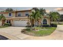 Exterior view of a two-story townhouse featuring a two-car garage and a landscaped front yard at 8990 Antigua Dr, Seminole, FL 33777