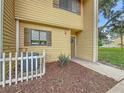 Inviting condo entrance with neat landscaping, picket fence and exterior light, showcasing a welcoming outdoor space at 22706 Gage Loop # 31, Land O Lakes, FL 34639