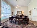 Formal dining room featuring a large window, chandelier, and traditional furnishings at 11501 Norval Pl, Temple Terrace, FL 33617
