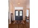 Elegant entryway with double doors, transom window, chandelier, and hardwood floors at 11501 Norval Pl, Temple Terrace, FL 33617