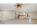 Open floor plan with tile flooring flows from the living area into a modern kitchen with a center island at 13116 Marathon Blvd, Port Charlotte, FL 33981