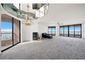 Bright living room with a fireplace, ceiling mirror, and large windows showcasing an ocean view at 1340 Gulf Blvd # 12A, Clearwater Beach, FL 33767