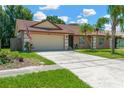 Inviting tan single story home with a well-manicured front yard and a spacious two-car garage at 1604 Dusty Rose Ln, Brandon, FL 33510