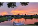 Picturesque sunset view over the tranquil water, featuring a private dock and lush surroundings at 1717 Danbury Dr, Sun City Center, FL 33573