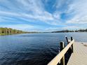 Stunning view of the lake from a wooden dock, showcasing serene waters and lush shoreline under a bright blue sky at 1821 Weekend Ln, Odessa, FL 33556