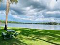 Scenic lake view with a shaded picnic area featuring lush green grass and beautiful skies; perfect for relaxation and outdoor enjoyment at 1821 Weekend Ln, Odessa, FL 33556