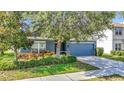 Charming single-Gathering home with a blue exterior, a well-manicured lawn, and an attached two-car garage at 18339 Fish Loop, Land O Lakes, FL 34638