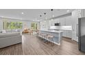 Bright, open-concept living space with modern kitchen island, dining area, and comfortable living room at 19259 Mossy Pine Dr, Tampa, FL 33647