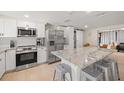 Bright modern kitchen featuring stainless steel appliances, quartz countertops, and a central island at 201 South St, Palm Harbor, FL 34683