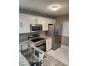 Updated kitchen featuring white cabinets, stainless steel appliances, and granite countertops at 2209 Belleair Rd # C3, Clearwater, FL 33764