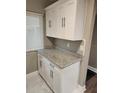 Bright kitchen featuring white cabinets, modern hardware, and granite countertops at 2209 Belleair Rd # C3, Clearwater, FL 33764