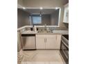 Galley kitchen features granite countertops, stainless steel appliances, and a double basin sink at 2209 Belleair Rd # C3, Clearwater, FL 33764