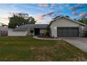 Charming single-story home featuring a well-maintained lawn and a two-car garage at 2319 Canfield Dr, Spring Hill, FL 34609