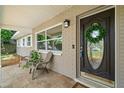 Inviting front porch with decorative door, stylish furniture, and lush plants at 2353 Eastwood Dr, Clearwater, FL 33765