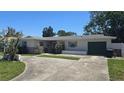 Inviting single-story home featuring a lush front yard and attached garage at 2502 Tropical Shores Se Dr, St Petersburg, FL 33705