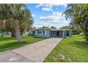 Beautifully landscaped front yard with a long driveway leading to a cozy home with neutral tones at 2701 Camellia Ter, Punta Gorda, FL 33950